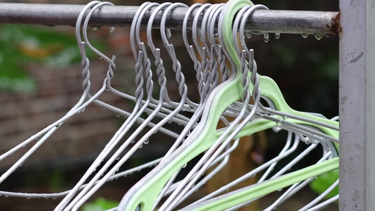 mano arreglando colgadores de ropa blanca en un estante