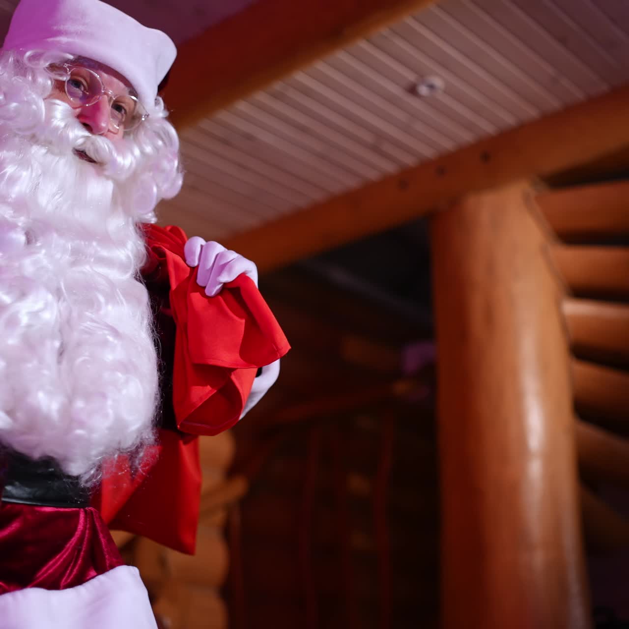 Santa Claus coming into the house quietly. Authentic Santa with white beard and red costume carrying presents to children at New Year's night