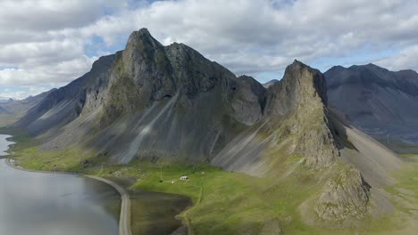 eystrahorn mountain aerial panning right to left, cloudy summer day, iceland