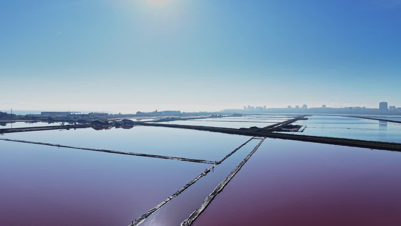 Salt production site with ponds and clear sky in a coastal area