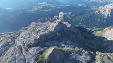 vista aérea de las dolomitas, con el escarpado pico de sassongher, con la ciudad de kolfuschg ubicada en el valle de abajo y vastas cadenas montañosas que se extienden en la distancia