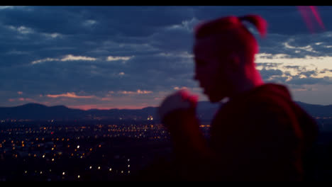 man meditating at sunset over cityscape