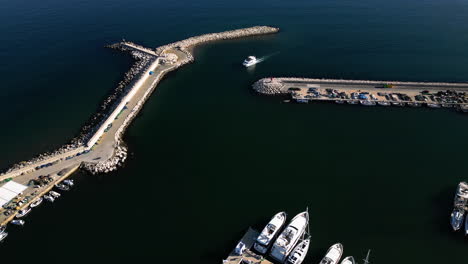 boat entering marina near estepona city, aerial drone view