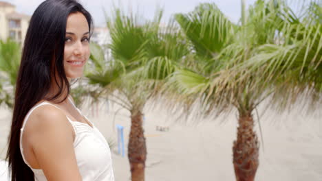 Mujer-Morena-Sonriendo-A-La-Cámara-En-La-Playa-Tropical