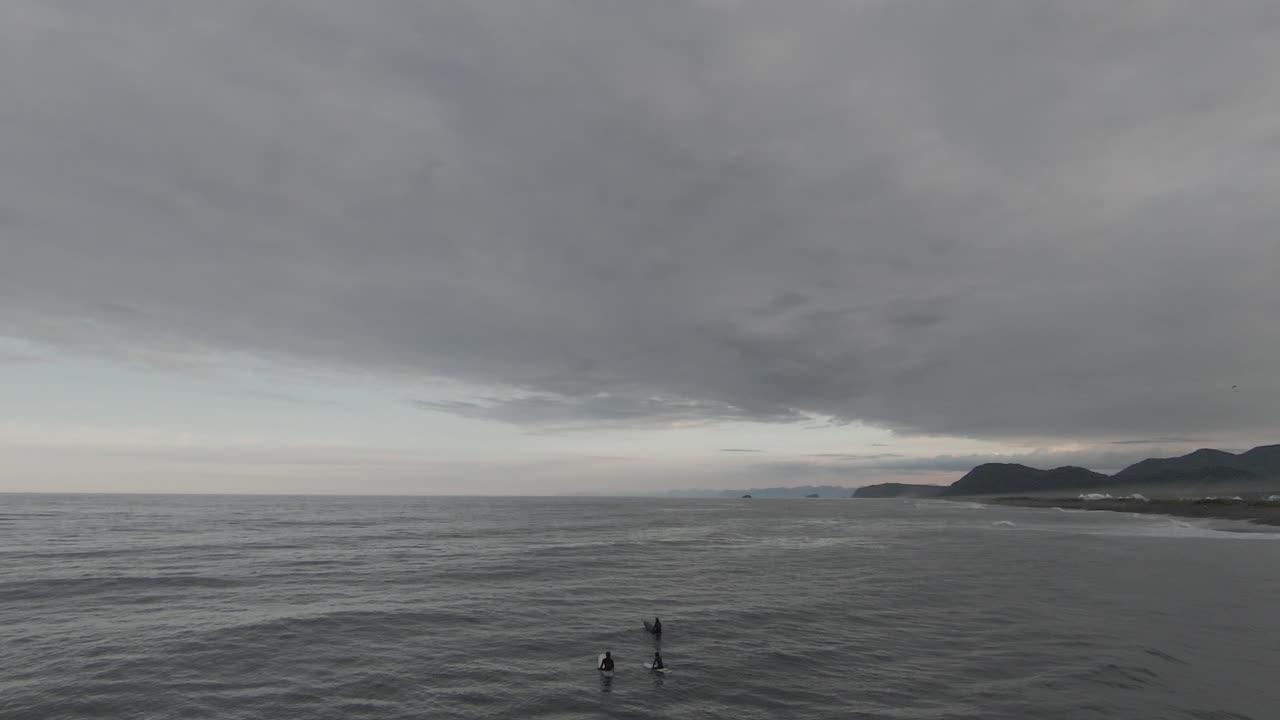 Surfers on a Cloudy Pacific Coast