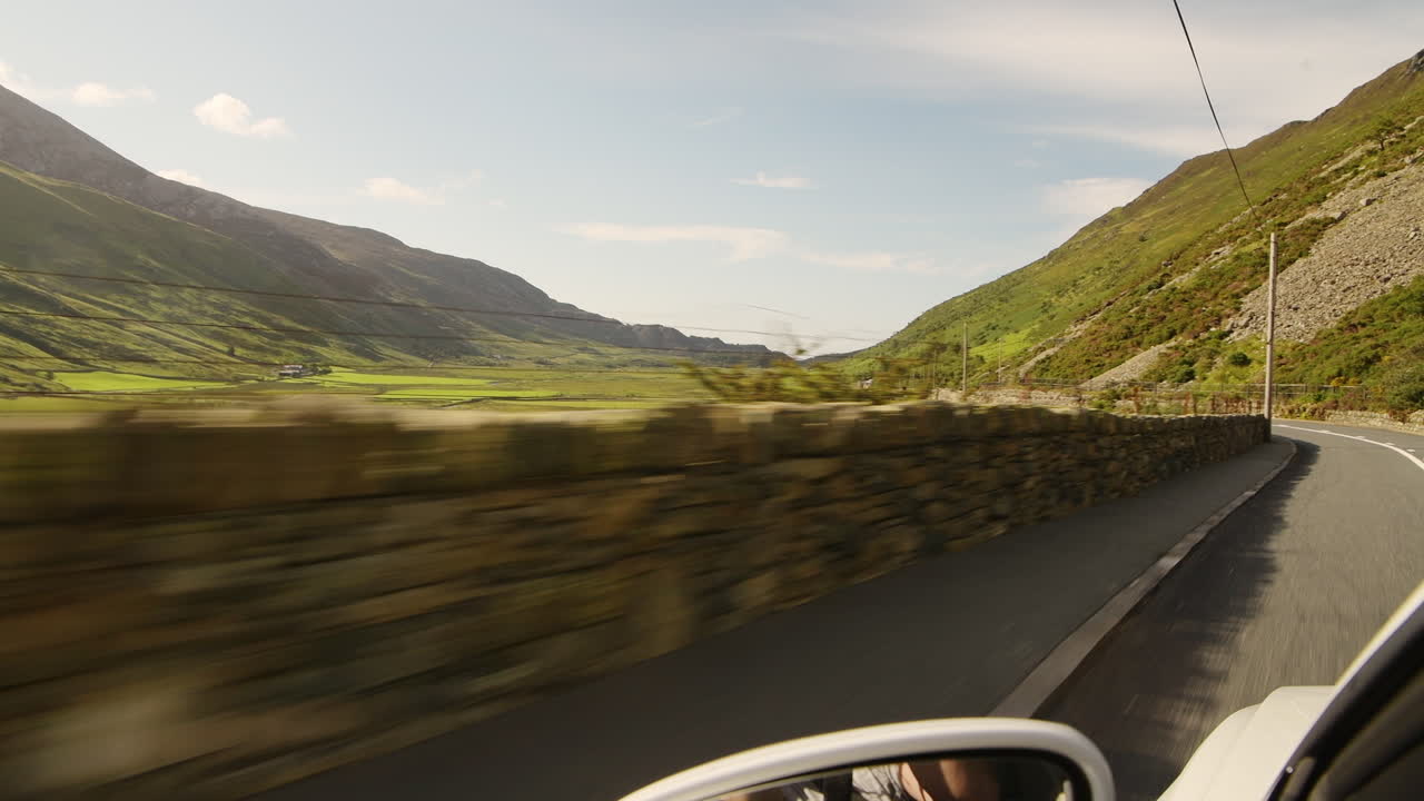Driving Fast On The Long And Winding Road At Snowdonia National Park In Wales, United Kingdom Before Sunset - rolling shot