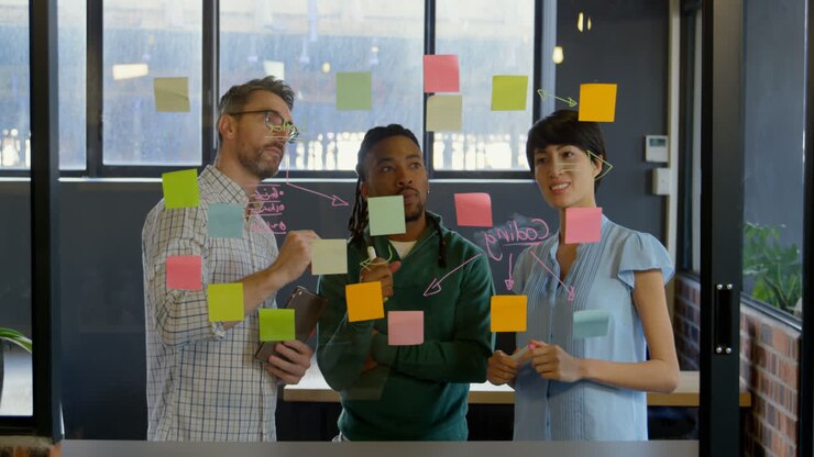 Business executives discussing over sticky note in office 4k