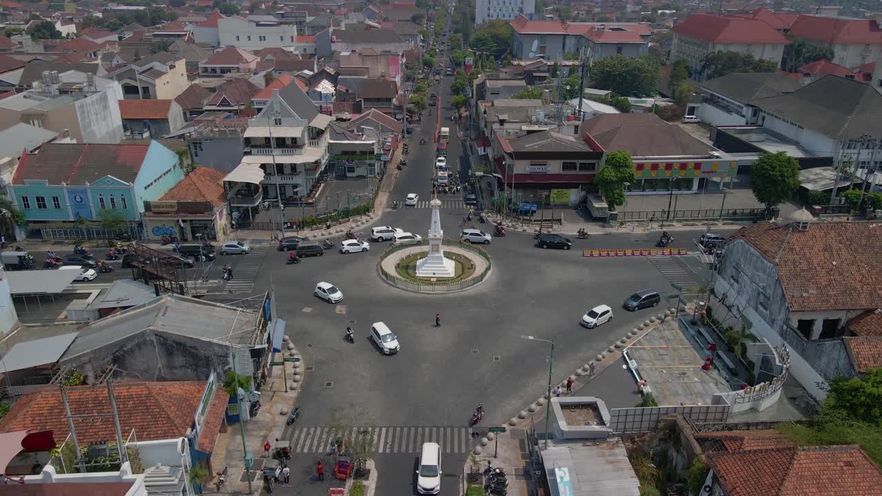 Reveal tracking drone shot of Tugu Yogyakarta Monument the iconic building of Yogyakarta City in rush hour - Cinematic drone movement