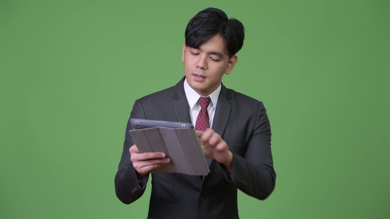 joven empresario asiático guapo usando una tableta digital