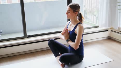 Caucasian-woman-doing-yoga-at-home-during-coronavirus-pandemic-with-words-Stay-Safe