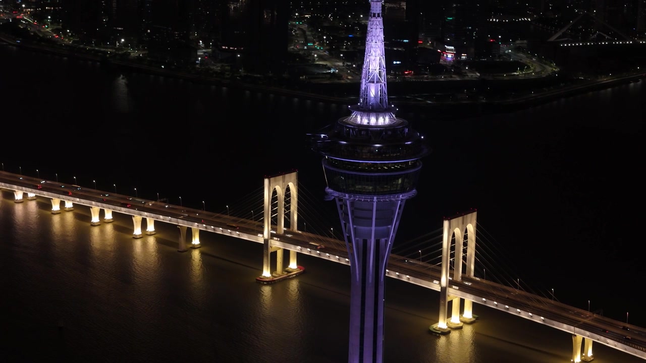 Primo piano della cima della Torre di Macao, Ponte Sai Van sullo sfondo, Macao di notte