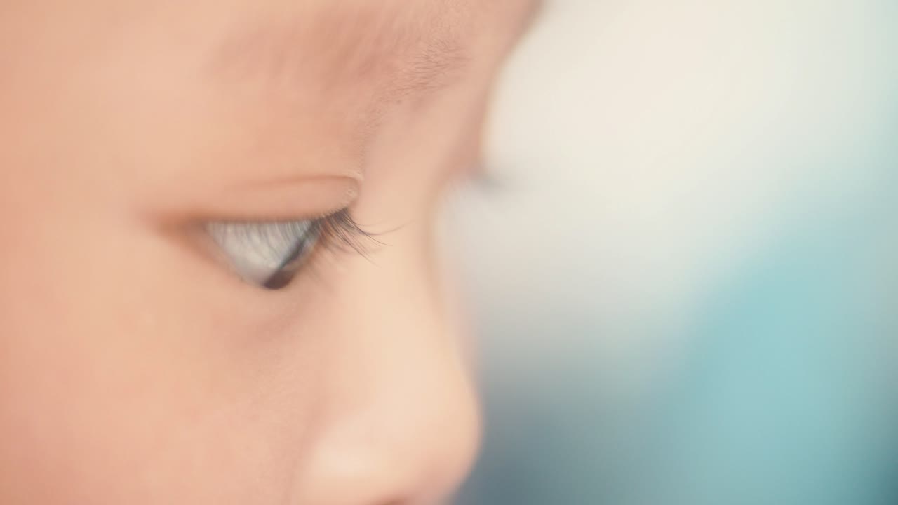 어린 아시아 아기의 얼굴을 닫고, 보케 배경을 가지고 놀면서 앉았다