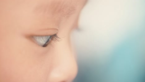 close up of young asian baby's face, sat up playing with bokeh background