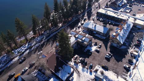 Aerial-View-of-Tahoe-City-Traffic-and-Lake-Tahoe-Coastline-on-Sunny-Winter-Day,-California-USA,-Revealing-Drone-Shot