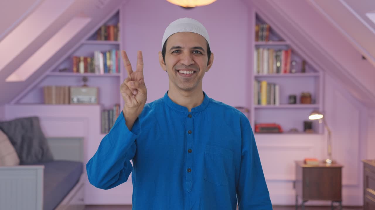 Glad muslimsk man visar segertecken