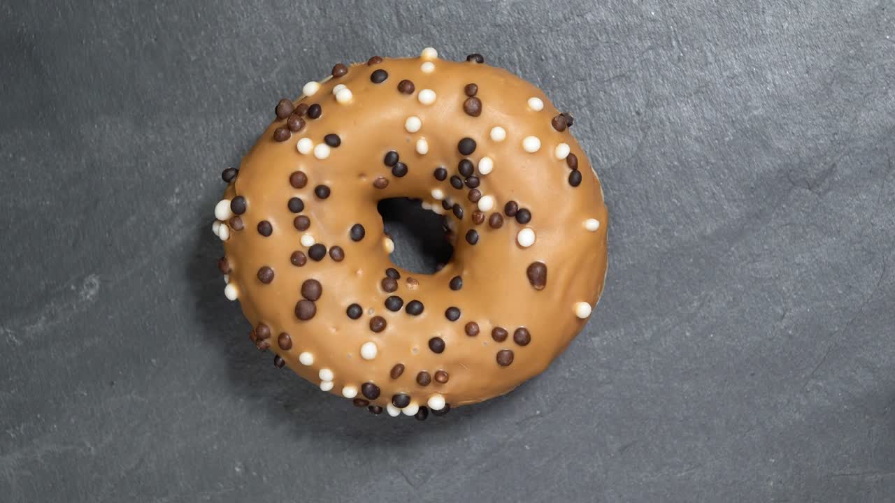 el donut dulce gira sobre un fondo oscuro. la dulzura tradicional estadounidense