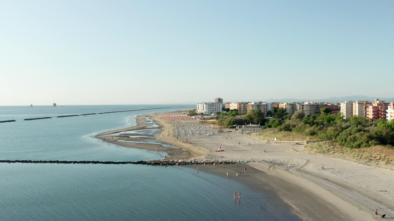 toma aérea de playa de arena con sombrillas, típica costa adriática