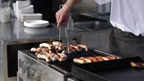 Cook-who-prepares-grilled-sausages-at-a-summer-party