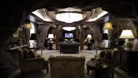 luxurious and elegant living room with unique rock-wall design and ambient lighting featuring comfortable seating and modern entertainment center