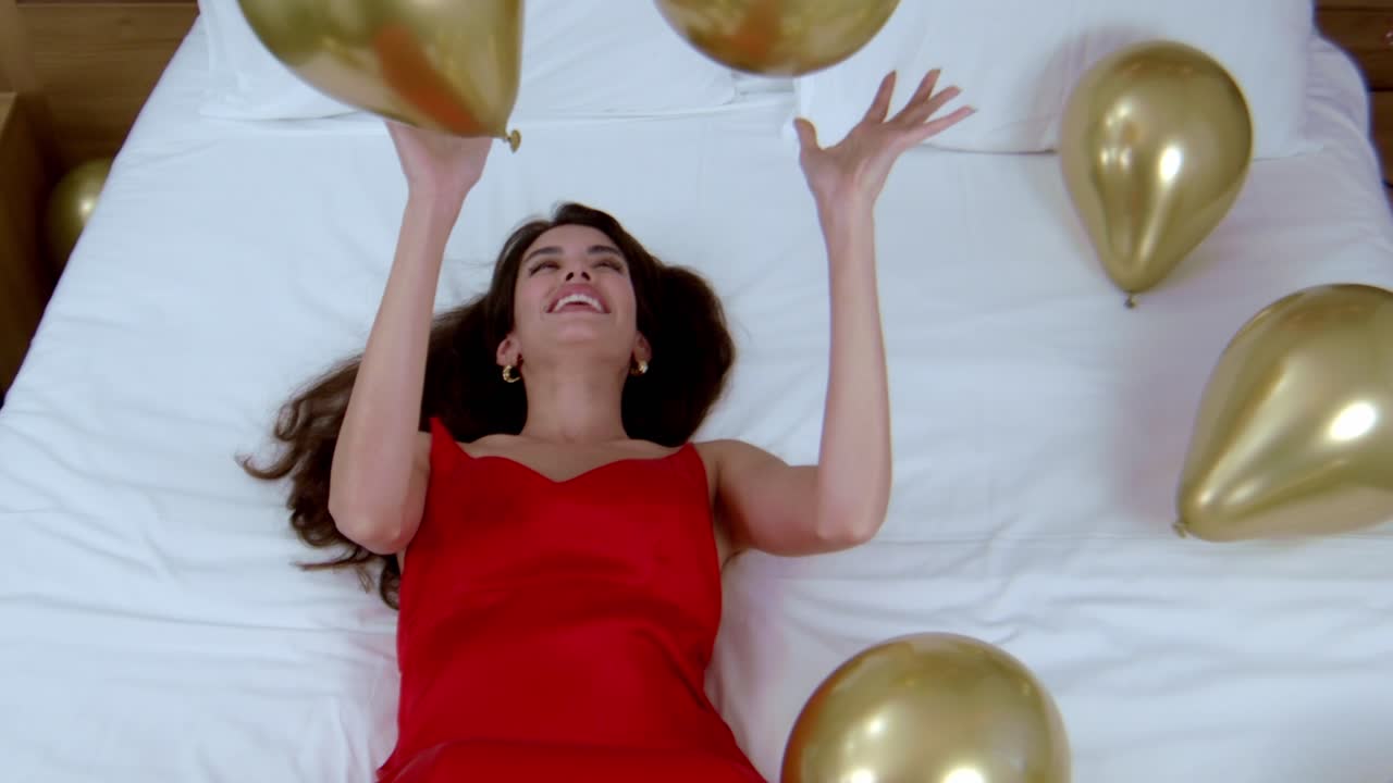 sesión de fotos de modelo en la ubicación del dormitorio que involucra accesorios de globos brillantes