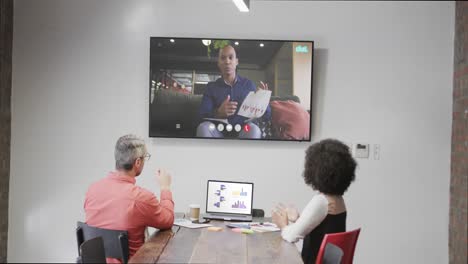 Diverse-business-people-on-video-call-with-african-american-male-colleague-on-screen