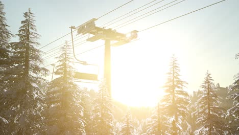 empty ski lift. chairlift silhouette on high mountain over the forest at sunset
