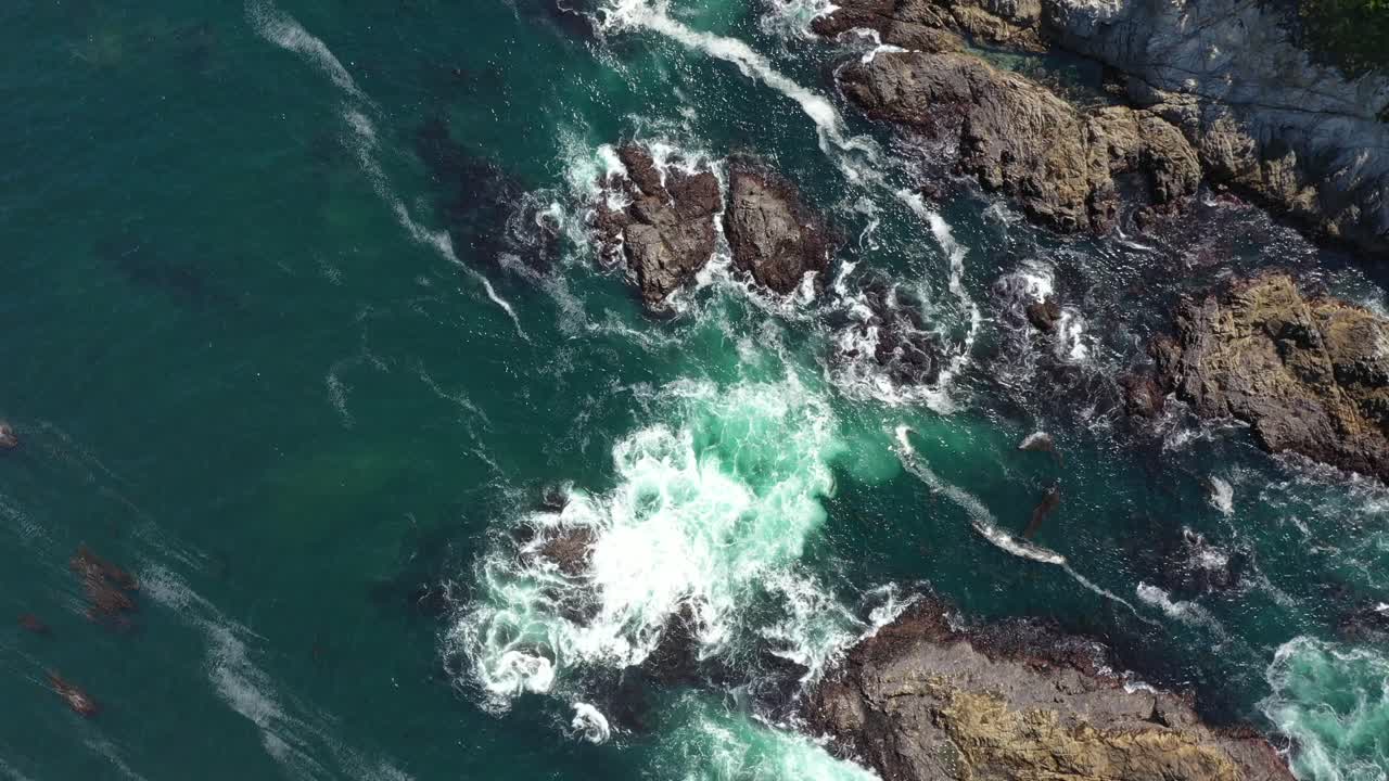Topdown Of Foamy Waves Splashing Over Outcrops In Big Sur Coastline In California, USA