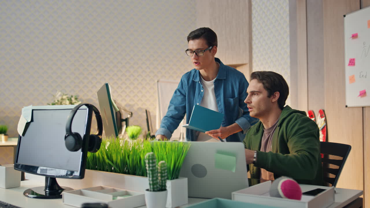 dos diseñadores eligiendo color mirando monitor lugar de negocio. hombres tormenta de ideas