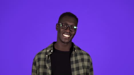 Happy,-confident-afro-american-man-in-casual-clothes-and-stylish-glasses-looking-at-camera-in-wide-toothy-smile-isolated-on-the-blue-background