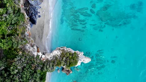 Playa-Bordeada-De-Rocas-Y-Agua-Cristalina-Brilla-En-Hermosos-Colores-Turquesa