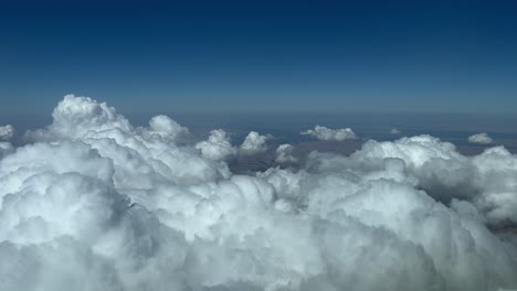 Vista-Aérea-Desde-La-Cabina-De-Un-Jet-Que-Sobrevuela-Algunos-Cúmulos-Diminutos-En-Una-Tarde-De-Verano