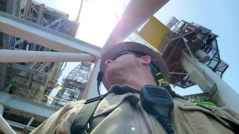 crew member operating drone equipment near a crane on an offshore oil rig