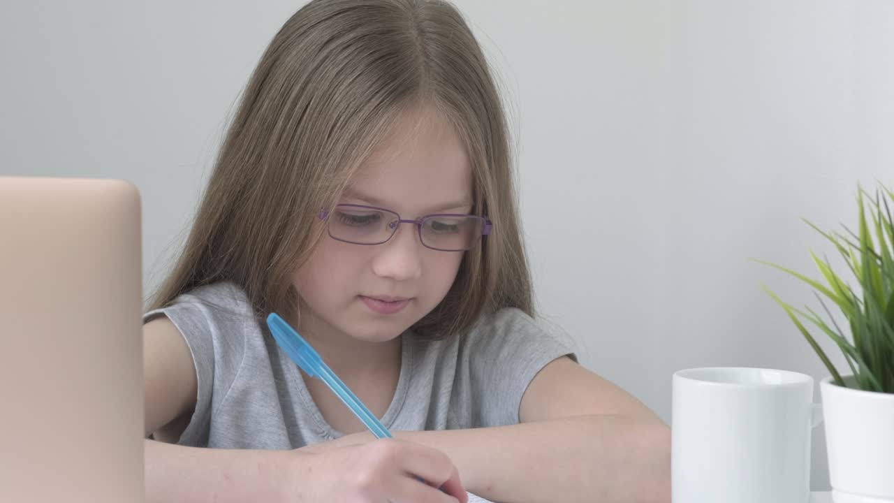 Caucasian kid studying online watching web class lesson or listening tutor by video call e-learning
