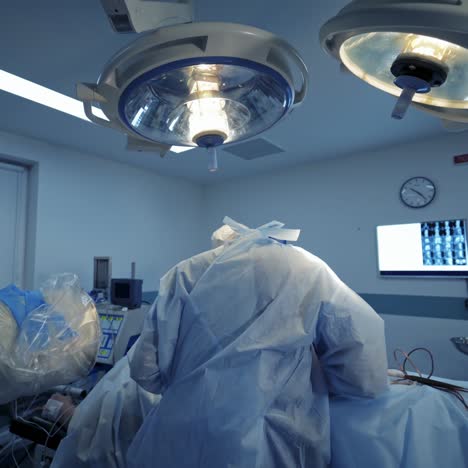 specialists in medical uniform are doing an operation in hospital. surgeon with magnifying glass on his head is working with assistants in the operating room