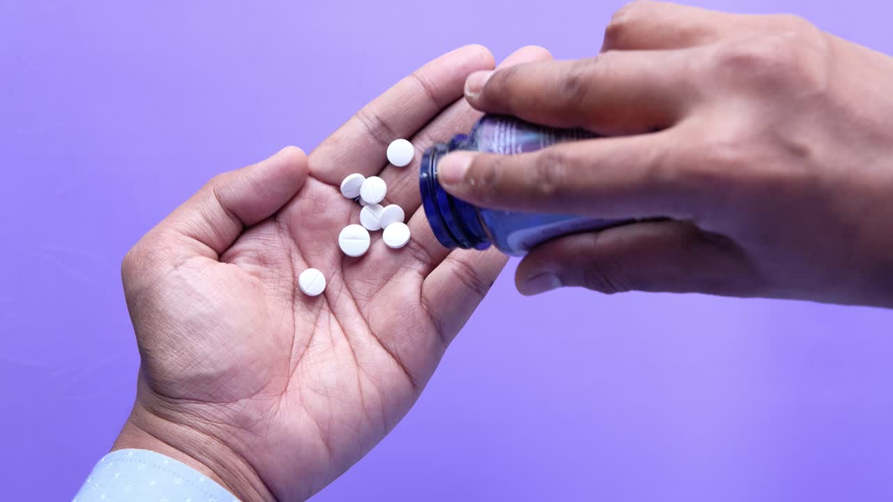 Person taking pills from a bottle