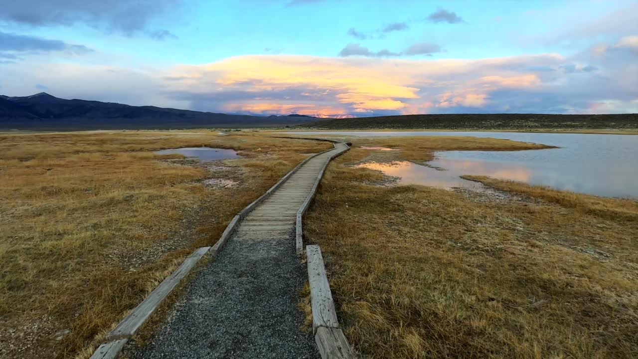 Walk path sunset Hilltop Wild Willy's Hot Springs California aerial drone clouds Benton Crossing Long Valley Caldera Canyon Minarets Sierra Nevada mountains Mammoth Lakes forward pan up motion