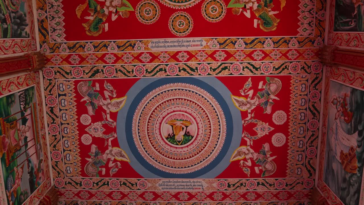 Colorful religious paintings on the interior of Pha That Luang Golden Stupa Buddhist Temple in Vientiane, Laos