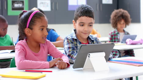 in school, children using tablet and studying together in classroom