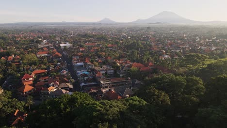 Vista-épica-Del-Amanecer-De-La-Ciudad-De-Ubud,-Famosa-Por-Sus-Artesanías-Tradicionales,-Con-El-Volcán-Agung-Al-Fondo-Y-Las-Selvas-En-Primer-Plano.