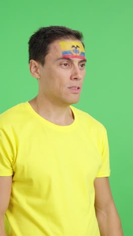 happy man with ecuadorian flag painted on face looking away