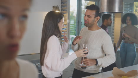 group of multi cultural friends enjoying drinks party with takeaway food at home together