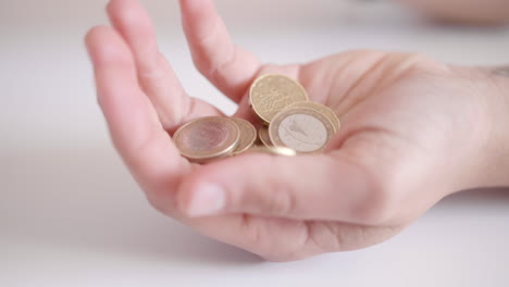 primer plano de monedas cayendo en una mano
