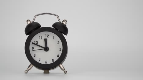 reloj despertador sobre un fondo blanco. movimiento rápido de las manas de la hora. manasa de minuto del reloj a un ritmo acelerado