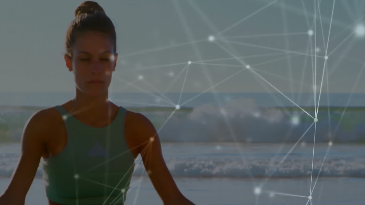 Yoga practitioner meditating on beach with network connections animation overlay