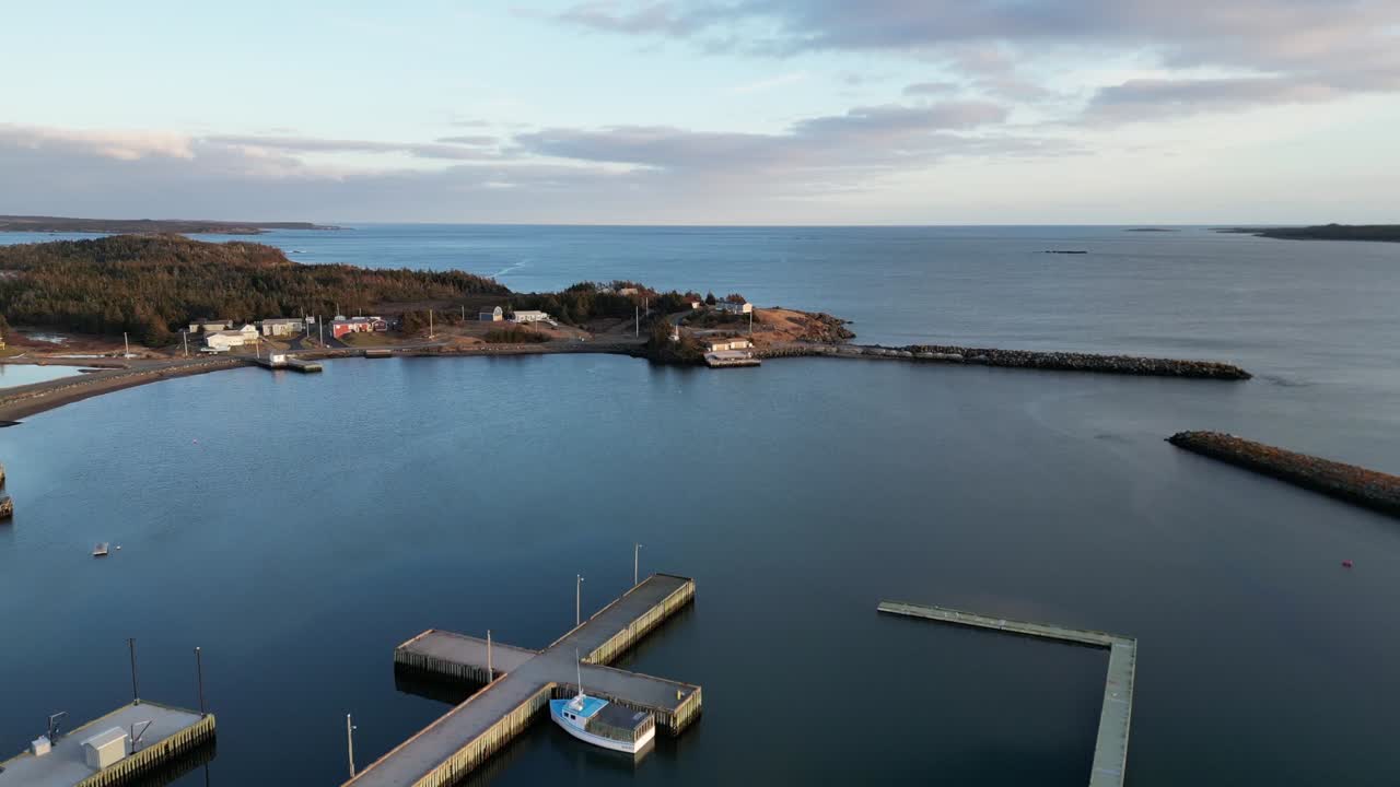 un vuelo sobre la bahía de mira desde la isla de scatarie, volando hacia una pequeña ciudad sobre el océano