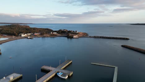 a fly over of mira bay from scatarie island, flying towards a small town over looking the ocean