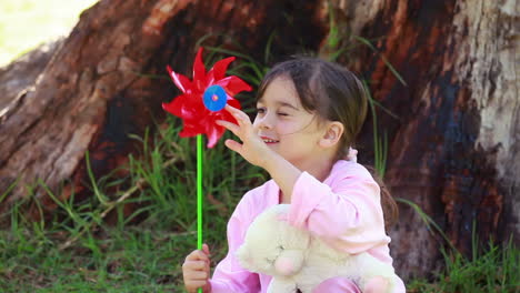 smiling girl holding a red pinwheel