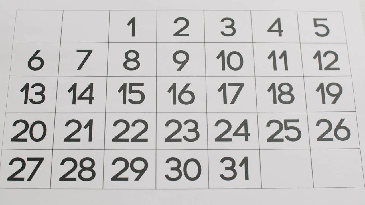 la mano del hombre escribe todo el día en el calendario de papel usando un bolígrafo rojo.