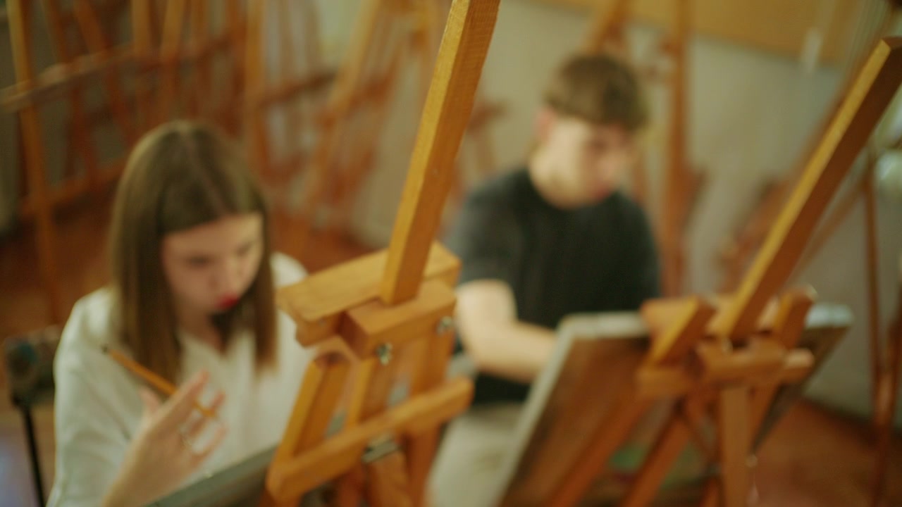 Jonge kunstenaars werken aan schetsen op ezels tijdens een klassikale sessie