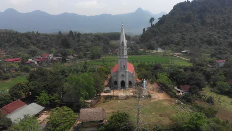 flying backwards at white catholic church at tuyên quang vietnam, aerial